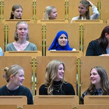 Junge Studierende sitzen in einem Hörsaal.