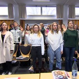 Junge Menschen halten für die Vereidigung ihre Hand in die Höhe.
