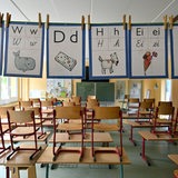 In einem Klassenzimmer stehen Stühle auf den Tischen.