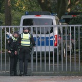 Polizeifahrzeuge fahren durch die Einfahrt des Friedhof Walle