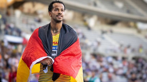 Zu sehen ist Bremer Sportler Leon Schäfer, er trägt eine Deutschland-Fahne als Umhang.