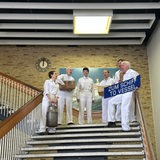 Schauspieler stehen in weißen Matrosenanzügen auf einer Treppe