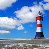 In der Wesermündung steht der Leuchtturm Roter Sand im Watt.