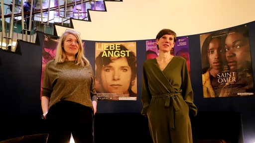 Kim Seligsohn und Sandra Prechtel stehen vor dem Plakat von "Liebe Angst".