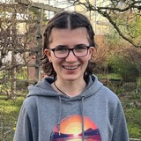Die Schülerin Janne Schmidmann mit Brille und Zahnspange lächelt in die Kamera.