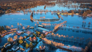 Eine Drohnenaufnahme zeigt Häuser und Wiesen, die in Lilienthal vom Hochwasser betroffen sind. 