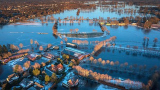 Eine Drohnenaufnahme zeigt Häuser und Wiesen, die in Lilienthal vom Hochwasser betroffen sind. 