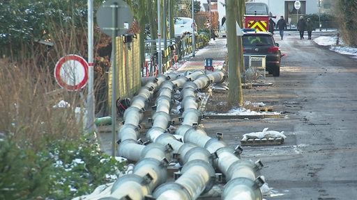 Viele Rohre liegen zur Bekämpfung von Hochwasser in einer Straße.