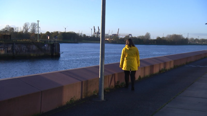 Eine Frau mit Lipödem an den Beinen steht am Weserufer.