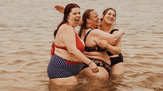 Drei junge Frauen vergnügen sich im Wasser