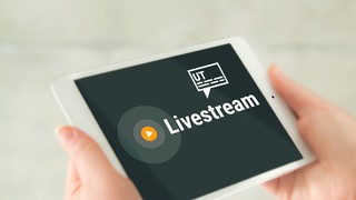 Zu sehen ist ein Tablet mit der Aufschrift "Livestream" und stilisierten Untertiteln.