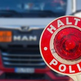 Eine Polizeikelle vor einem LKW