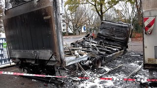 Ein ausgebrannter Lkw steht auf einem Parkplatz in Bremen-Obervieland.