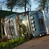Ein Lastwagen liegt neben der Fahrbahn auf der Seite.