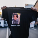 Ein Demonstrant hält vor einer Kundgebung ein schwarzez T-Shirt in die Kamera, auf dem der von Polizeischüssen getötete Lorenz aus Oldenburg abgebildet ist.