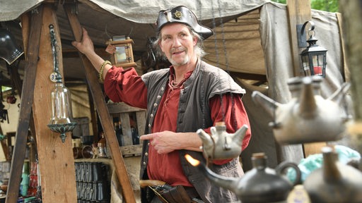 Ein als Pirat verkleideter Mann steht vor einem Zelt.
