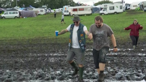 Zwei Männer auf einer Wiese, im Schlamm.