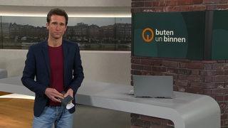 Moderator János Kereszti im Studio von buten un binnen.