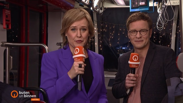 Die Moderatorin Kirsten Rademacher und der Moderator Felix Krömer in der buten un binnen Straßenbahn.