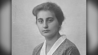 Ein schwarz-weiß Foto von einer jungen Frau aus der Zeit des Zweiten Weltkriegs, sie hat die Haare zurückgebunden und ihr Gesichtsausdruck ist neutral.