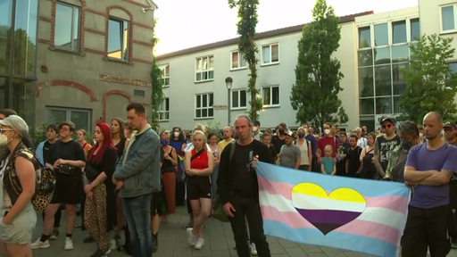 Zahlreiche Menschen bei einer Mahnwache gegen queerfeindliche Gewalt.