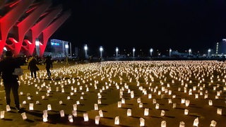 Auf der Bürgerweide stehen Kerzen, die an gestorbene Geflüchtete erinnern.