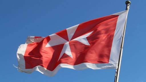 Maltesische Flagge weht vor blauem Himmel (Symbolbild)