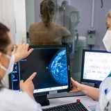 Medizinisches Personal untersucht mit einer Mammografie die Brust einer Frau auf Brustkrebs. 