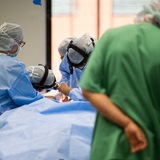 Ein Team aus Ärzten und Operationshelfern steht in einem in der HNO-Operationssaal an einem Tisch.