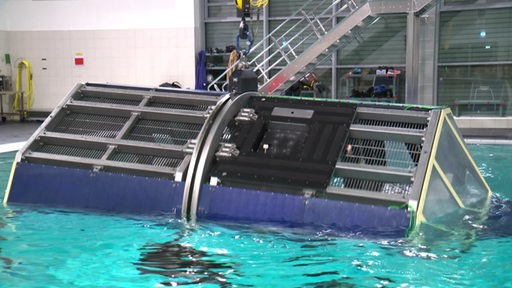 Simulationshubschrauber wird in ein Schwimmbecken gelassen