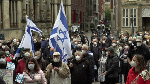 Viele Menschen die sich auf dem Bremer Marktplatz befinden. Die meisten tragen einen Mund- und Nasenschutz und vereinzelt israelische Flaggen.
