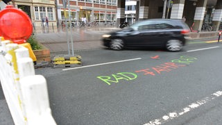 Auto muss vor Vollsperrung abbiegen, Schriftzug "Rad Fahr Rad" auf der Fahrbahn