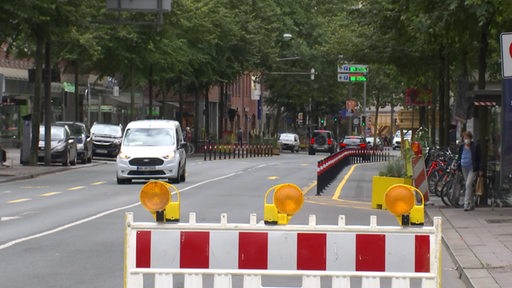 Die Martinistraße in Bremen während der Verkehrsversuche im Sommer 2021. Eine Fahrbahn ist für Autos gesperrt und rechts ist eine Fahrradstrecke mit Pollern abgegrenzt.
