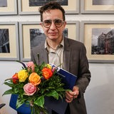 Masha Gessen, Publizistin aus den USA, lächelt nach der Übergabe des Hannah-Arendt-Preises in die Kamera und hält einen Blumenstrauß in der Hand.