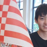 Jizhe Ma, Schüler der 10. Klasse am Lloyd-Gymnasium Bremerhaven neben der Bremer Speckflagge