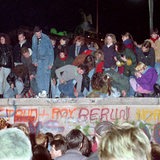 Einen Tag nach der Grenzöffnung in Berlin feiern tausende Menschen auf, vor und hinter der Berliner Mauer am Brandenburger Tor, aufgenommen am 10. November 1989 auf West-Berliner Seite.