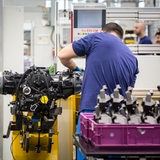 Auszubildender zum Karosserie- und Fahrzeugbaumechaniker schraubt an Bauteil