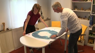 Die Wissenschaftler gucken sich eine neue Karte des Meeresboden des Südpolarmeeres an. 