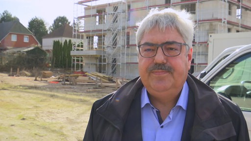 Bremerhavens Oberbürgermeister Melf Grantz im Inteview vor einer Baustelle.