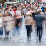 Viele Menschen laufen durch eine Innenstadt.