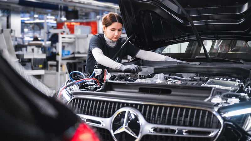 Eine junge Frau arbeitet am Fließband der Autoproduktion in Halle 9 im Bremer Mercedes-Werk.