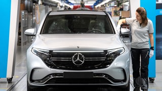 Mitarbeiterin von Mercedes-Benz kontrolliert einen Wagen vor der Ausfahrt aus dem Mercedes-Werk in Bremen