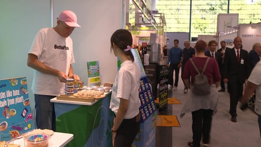 Eine Frau guckt sich einen Messestand in Bremen an.