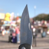 Ein großes Klappmesser. Im Hintergrund der Bremer Freimarkt. 
