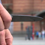 Ein Messer wird in der Hand gehalten.