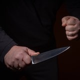 Eine geballte Faust neben einem gezücktem Messer. (Symbolbild)