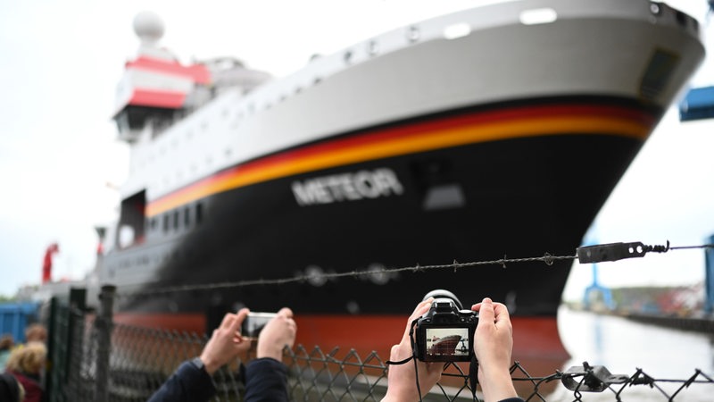 Ein Forschungsschiff wird von Schaulustigen fotografiert
