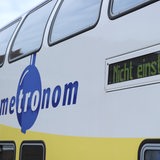 Ein Zug mit dem Logo "Metronom" und einer Digitalanzeige, die "Nicht einsteigen" anzeigt.