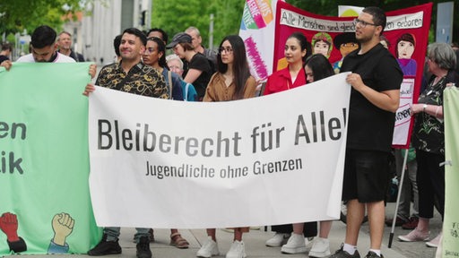 Auf einem großen Banner von Aktivisten, die gegen die Abschiebung sind, steht "Bleiberecht für Alle! Jugendliche ohne Grenzen"