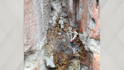 Miniaturfiguren in einer Lücke einer Hausmauer in Leeuwarden.